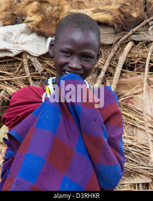 Ein Masai Mädchen schaut verschämt Ino der Kamera. Serengeti Nationalpark, Tansania Stockfoto