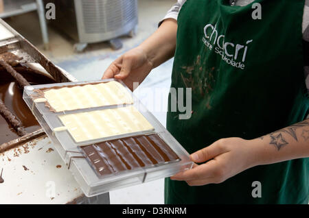 Berlin, Deutschland, Mitrabeiterin von Chocri Schokolade füllt verschiedene Standorte in Formen Stockfoto