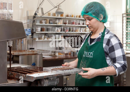 Berlin, Deutschland, Mitrabeiterin von Chocri füllt eine Schokolade Orte in Formen Stockfoto