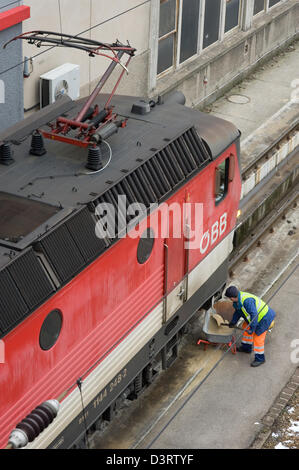 Wien, Österreich, der Arbeitnehmer ÖBB werfen Sand vor einer Lok auf die Gleise Stockfoto