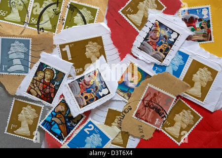 Stapel von gebrauchten Britischen Briefmarken abgerissen Umschläge und Postkarten Stockfoto