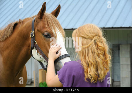 Rote kurzhaarige Mädchen streicheln ihr Pferd, eine 18 Jahre alte Teenager mit ihrem Tier. Stockfoto