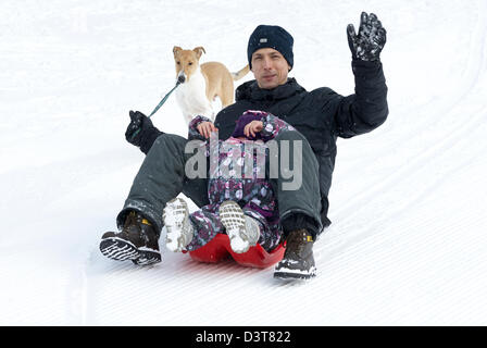 Vater und Tochter Schlitten fahren im winter Stockfoto