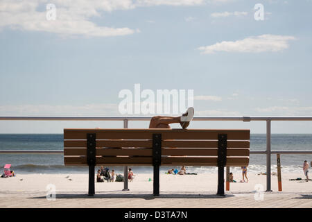 Ein Strand-Goer entspannt auf einer Promenade Bank Long Beach, New York. Stockfoto
