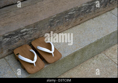 Ein paar hölzerne Geta Clog-Typ Sandalen getragen von buddhistischen Mönchen auf den Stufen des Tempels in Japan. Stockfoto