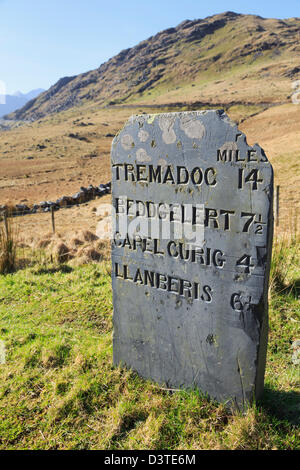 Alten Schiefer Meilenstein zeigt Entfernungen in imperialen Meilen oberhalb Nant Gwynant in Snowdonia-Nationalpark, Gwynedd, Nordwales, UK Stockfoto