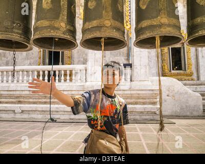 24. Februar 2013 Ringe - Bangkok, Thailand - A Boy Gebet Glocken an Wat Hua Lamphong. Wat Hua Lamphong ist ein Royal buddhistischer Tempel, dritte Klasse, in der Bang Rak Viertel von Bangkok, Thailand. Es befindet sich an der Rama IV Road, etwa 1 km von der Stadt Hua Lamphong Hauptbahnhof. Ein Eingang zu Sam Yan Station auf der Bangkok Metro (u-Bahn) befindet sich vor dem Haupteingang des Tempels Verbindung auf Rama IV. Wat Hua Lamphong wurde 1996 anlässlich des 50. Jahrestages der Aufstieg auf den Thron von König Bhumibol Adulyadej (Rama IX) im Jahr 1996 renoviert. Das königliche Siegel von was wurde kno Stockfoto