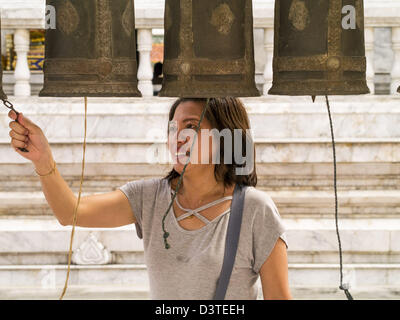 24. Februar 2013 Ringe - Bangkok, Thailand - eine Frau Gebet Glocken an Wat Hua Lamphong. Wat Hua Lamphong ist ein Royal buddhistischer Tempel, dritte Klasse, in der Bang Rak Viertel von Bangkok, Thailand. Es befindet sich an der Rama IV Road, etwa 1 km von der Stadt Hua Lamphong Hauptbahnhof. Ein Eingang zu Sam Yan Station auf der Bangkok Metro (u-Bahn) befindet sich vor dem Haupteingang des Tempels Verbindung auf Rama IV. Wat Hua Lamphong wurde 1996 anlässlich des 50. Jahrestages der Aufstieg auf den Thron von König Bhumibol Adulyadej (Rama IX) im Jahr 1996 renoviert. Das königliche Siegel von was wurde k Stockfoto