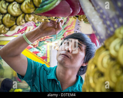 24. Februar 2013 - Bangkok, Thailand - ein Wärter malt die Drachen die Wache den Eingang zum '' Sarg Tempel '' der Ruamkatanyu-Stiftung neben Wat Hua Lamphong. Die Ruamkatanyu-Stiftung bietet Särge Bangkoks mittellosen und Notfall medizinische Dienstleistungen für Unfallopfer in Bangkok. Wat Hua Lamphong ist ein Royal buddhistischer Tempel, dritte Klasse, in der Bang Rak Viertel von Bangkok, Thailand. Es befindet sich an der Rama IV Road, etwa 1 km von der Stadt Hua Lamphong Hauptbahnhof. Ein Eingang, Sam Yan Station auf der Bangkok Metro (u-Bahn) liegt außerhalb der wichtigsten e Stockfoto