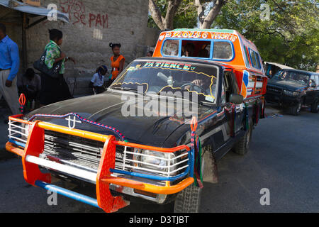 Klapses Busse vorbei durch die Innenstadt von Port-au-Prince. -Klapses Fahrzeuge dienen als öffentliche Verkehrsmittel in Haiti. Stockfoto