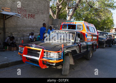 Klapses Busse vorbei durch die Innenstadt von Port-au-Prince. -Klapses Fahrzeuge dienen als öffentliche Verkehrsmittel in Haiti. Stockfoto