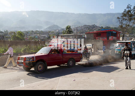 Klapses Busse vorbei durch die Innenstadt von Port-au-Prince. -Klapses Fahrzeuge dienen als öffentliche Verkehrsmittel in Haiti. Stockfoto