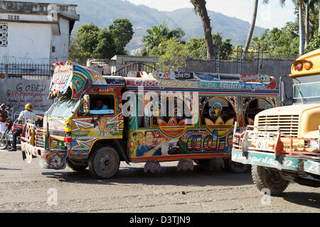 Klapses Busse vorbei durch die Innenstadt von Port-au-Prince. -Klapses Fahrzeuge dienen als öffentliche Verkehrsmittel in Haiti. Stockfoto