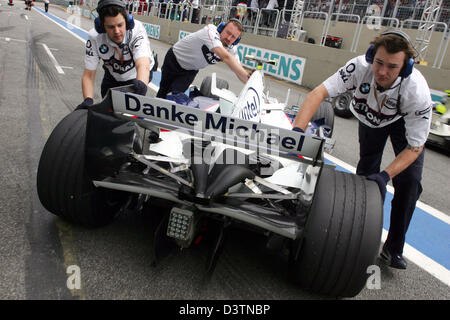 Mechanik zurückschieben das Auto des deutschen Formel1 Test-Pilot Sebastian Vettel von BMW Sauber während des zweiten Trainings an der Interlagos Rennstrecke in der Nähe von Sao Paulo, Brasilien, Freitag, 20. Oktober 2006. Die hinteren Kotflügel BMW Sauber-Autos verfügen über eine Hommage an Michael Schumacher. Grand Prix von Brasilien statt findet am Sonntag, 22. Oktober. Foto: Gero Breloer Stockfoto