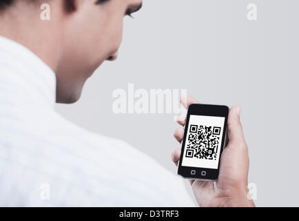 Man betrachtet den 2D Barcode auf dem Handy Stockfoto