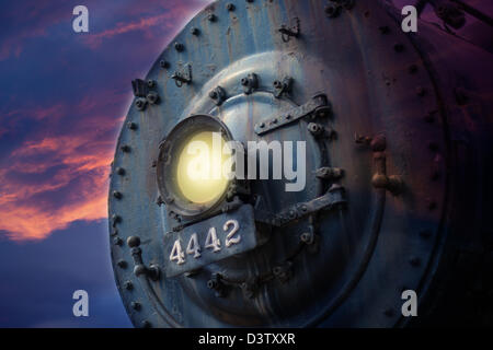 Vorderseite der Dampfmaschine Lok mit Licht in dunklen Himmel Stockfoto