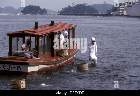 (Dpa-Datei) - die undatierte Bild zeigt einen japanischen Pearl Diver Sprung ins Wasser in Japan. Jede Perle Taucher hat einen Holzbottich, die Austern Perlen zu sammeln. Foto: Hinrich Baesemann Stockfoto