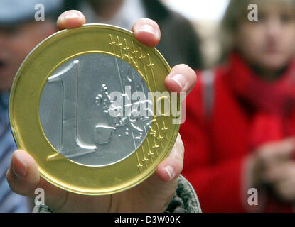 (Dpa-Dateien) - das symbolische Foto zeigt eine überdimensionale-Euro-Münze in der Hand eines Verbrauchers in Frankfurt Main, Deutschland, Samstag, 2. Dezember 2006. Einzelhändler begnügten sich mit ihren Umsatz nach dem ersten Adventswochenende mit längeren Öffnungszeiten. Foto: Boris Roessler Stockfoto