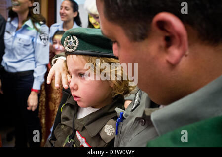 Jerusalem, Israel. 25. Februar 2013. Ein kleiner Junge ist neben seinem Vater, eine Portion Grenze Polizist, in der Israel Polizei nationale Hauptquartier Oberkommando Tagungsraum für Purim als Grenze Polizist gekleidet. Jerusalem, Israel. 25. Februar 2013.  Kinder von Polizisten in Purim Polizei Kostüme, die Positionen des Oberkommandos Israel Polizei im nationalen HQ Mann. Purim, gedenkt eines bunter Feiertage des Judentums, der wunderbare Rettung der Juden aus einem persischen Völkermord Grundstück... Bildnachweis: Nir Alon / Alamy Live News Stockfoto