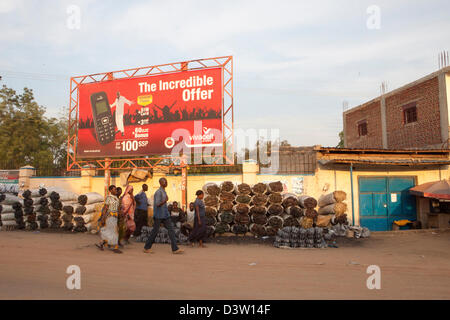 JUBA, Südsudan, 19. November 2012: Holzkohle Straße Verkäufer und Handy-Plakat. Stockfoto