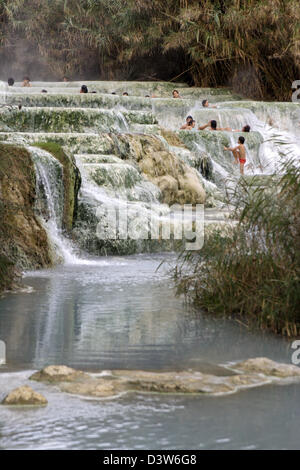 (Dpa-Datei) - das Bild zeigt die Leute Baden in den Kaskaden der Thermalquellen in der Therme Saturnia, Italien, 25. November 2006. Das sulfurized Wasser fließen in eine natürliche Sinter-Becken, die verwendet werden können unentgeltlich. Bei einem nahe gelegenen Health können Resort Besucher aus verschiedenen Behandlungen und Therapien. Foto: Lars Halbauer Stockfoto