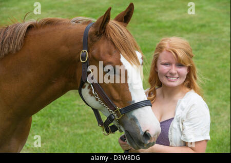 Lächelndes Mädchen mit ihrem Pferd im Portrait, Kopf geschossen rote behaarte Teenager und ihr Tier. Stockfoto