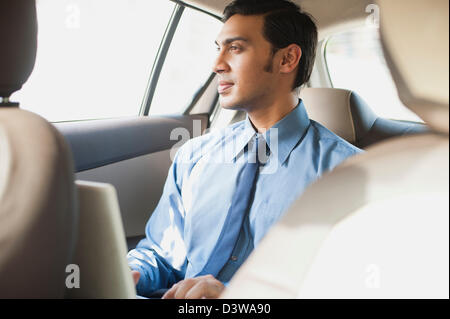 Bengali Geschäftsmann mit einem Laptop in ein Auto Stockfoto