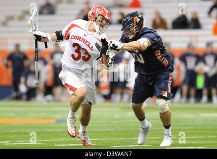 Syracuse, New York, USA. 24. Februar 2013.  Cornell Big Red Mittelfeldspieler weicht Connor Buczek #33, das Tor gegen Hobart Staatsmänner Mittelfeldspieler Jesse Mancuso #10 im zweiten Quartal eines NCAA Lacrosse-Spiel zwischen den Hobart Staatsmänner und die Cornell Big Red im Carrier Dome in Syracuse, New York.  Bildnachweis: Cal Sport Media / Alamy Live News Stockfoto