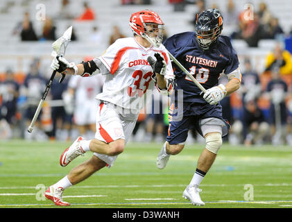 Syracuse, New York, USA. 24. Februar 2013.  Cornell Big Red Mittelfeldspieler weicht Connor Buczek #33, das Tor gegen Hobart Staatsmänner Mittelfeldspieler Jesse Mancuso #10 im zweiten Quartal eines NCAA Lacrosse-Spiel zwischen den Hobart Staatsmänner und die Cornell Big Red im Carrier Dome in Syracuse, New York.  Bildnachweis: Cal Sport Media / Alamy Live News Stockfoto