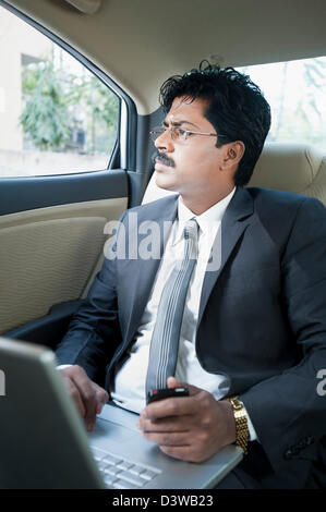 Südindische Geschäftsmann Blick durch das Fenster eines Autos Stockfoto