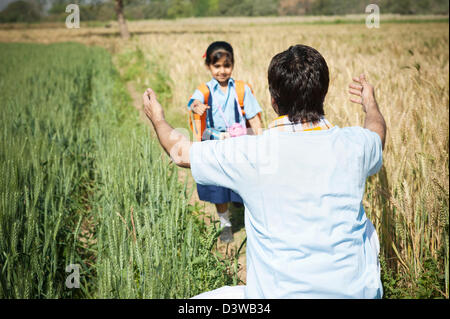 Bauer, seine Tochter im Feld Sohna, Haryana, Indien zu umarmen Stockfoto