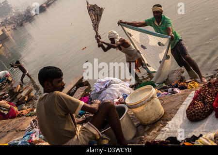 Indische Männer hand Waschen von Kleidung in den Ganges, Varanasi, Indien Stockfoto