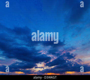 Sonnenuntergang am tiefblauen Himmel mit vielen Cumulus-Wolken. Panorama aus mehreren Fotos. Stockfoto