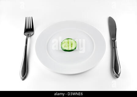 Die abgeschnittene Scheibe Gurke liegt auf einem weißen Teller Stockfoto