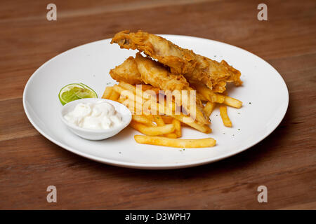 Garnelen-Tempura-Gericht mit weißer Soße und Pommes frites in weißer Teller auf Holztisch Stockfoto