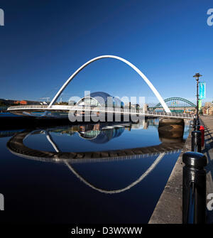 Ein sonnige tagsüber Blick im Sommer von Gateshead Millennium Bridge spiegelt sich in den Fluss Tyne mit Blick auf die Tyne Bridge Stockfoto