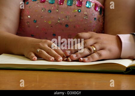 Braut und Bräutigam Hand in Hand und zeigt ihre Eheringe. Stockfoto