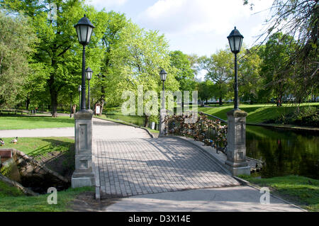 Eine kleine Brücke mit Vorhängeschlössern im Kronvalda Park und dem Stadtkanal neben der Altstadt von Riga, Riga, Lettland, den baltischen Staaten Stockfoto