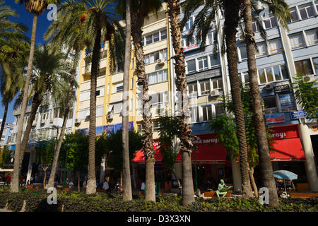 Humorvolle Bronzestatue eines Mannes auf eine Bank und liest eine Zeitung in alten griechischen Gewändern auf Atatürk Boulevard Antalya Türkei Stockfoto