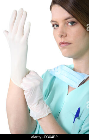 Weibliche Medic in Scrubs ziehen an einen Gummihandschuh Stockfoto