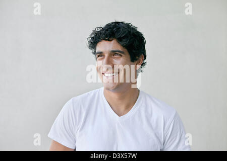 Porträt des jungen Männchen mexikanisch-amerikanischen tragen schlichte weiße T-shirt und Khakis lächelnd Stockfoto
