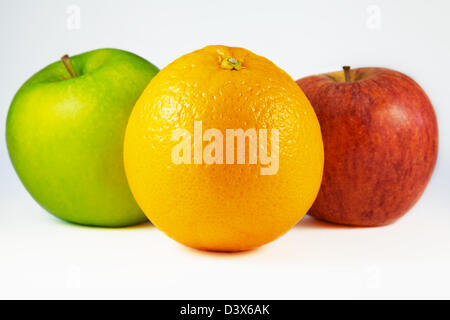 Zwei Äpfel, eine rote und eine grüne und eine Orange isoliert auf weiss Stockfoto