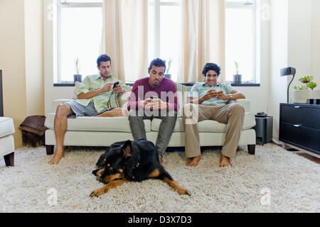 Hispano-amerikanischen Jungen sitzen im Wohnzimmer warten gelangweilt Stockfoto