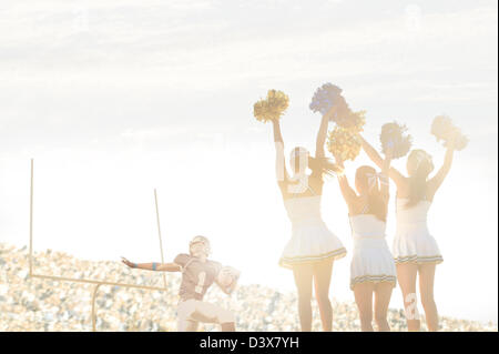 Kaukasische Cheerleader am Rande bei Fußballspiel Stockfoto