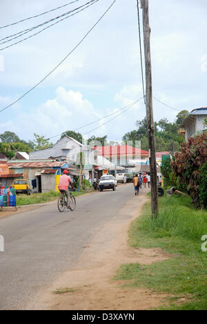 Ein Mann in einem rosa Hemd Zyklen in einer ruhigen Straße in Madagaskar Stockfoto