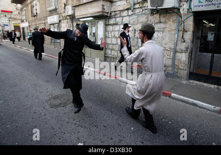 Betrunkene Haredi-Juden, die während des jüdischen Urlaubs von Purim in Mea Shearim, einer ultraorthodoxen Enklave in Westjerusalem Israel, auf der Straße tanzten Stockfoto