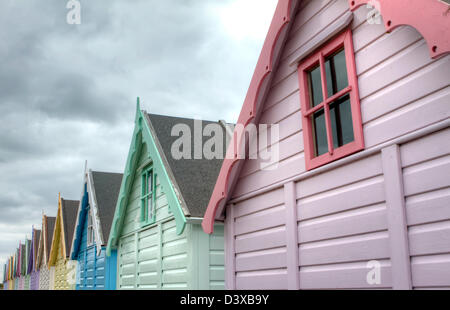 Mersea, Essex. Reihe von bunten traditionellen Strandhütte Stockfoto