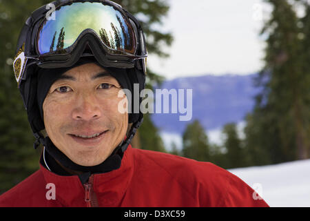 Chinesischer Mann tragen Skiausrüstung im Schnee Stockfoto