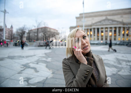 Frau am Handy auf große Weltkarte in Washington, D.C. Stockfoto