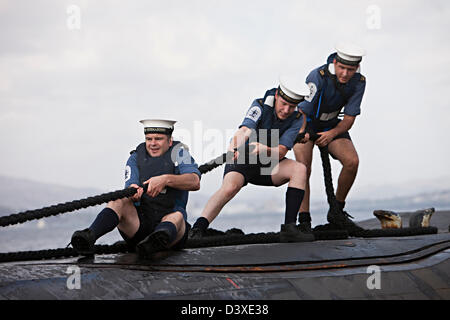 Drei Matrosen ziehen ein Seil an Deck der nuklearen u-Boot HMS Talent, Ägypten Stockfoto